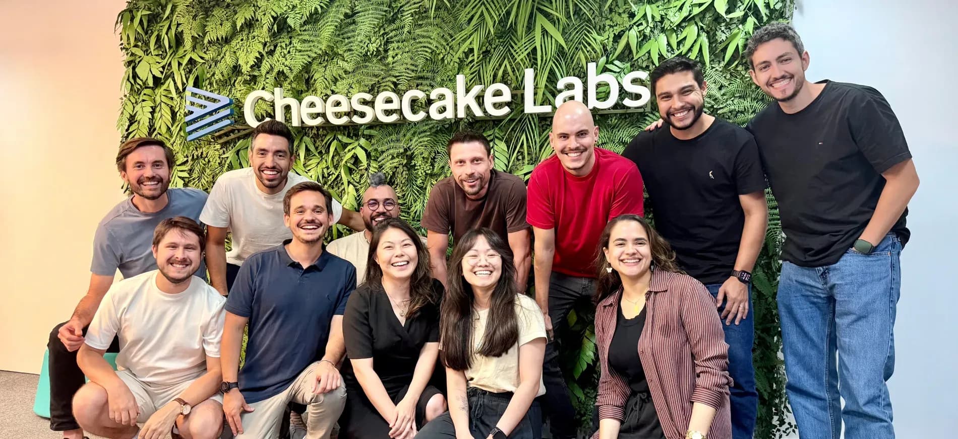 Cakers gathered in front of the Cheesecake Labs plant wall